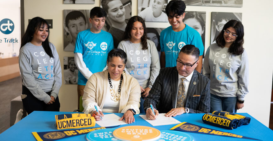 College Track President & CEO Shirley M. Collado and UC Merced Chancellor Juan Sánchez Muñoz sign a partnership between the two entities.
